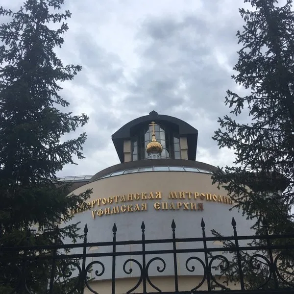 Купол с крестом над зданием Уфимского епархиального управления на улице Коммунистической, вид с улицы из-за елей